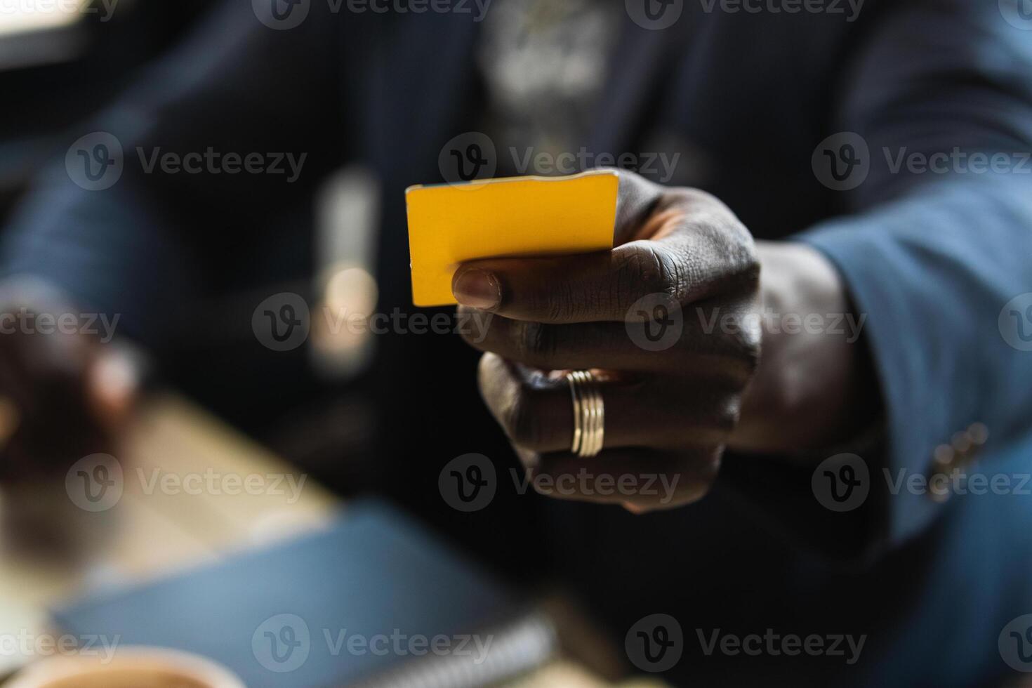 Anonymous crop black executive with business card in cafe photo