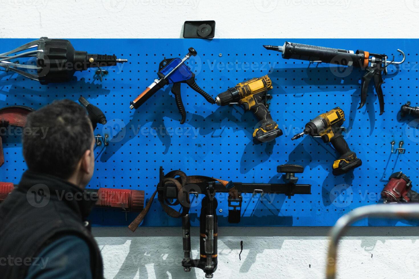 Anonymous repairman choosing tools during work in garage photo