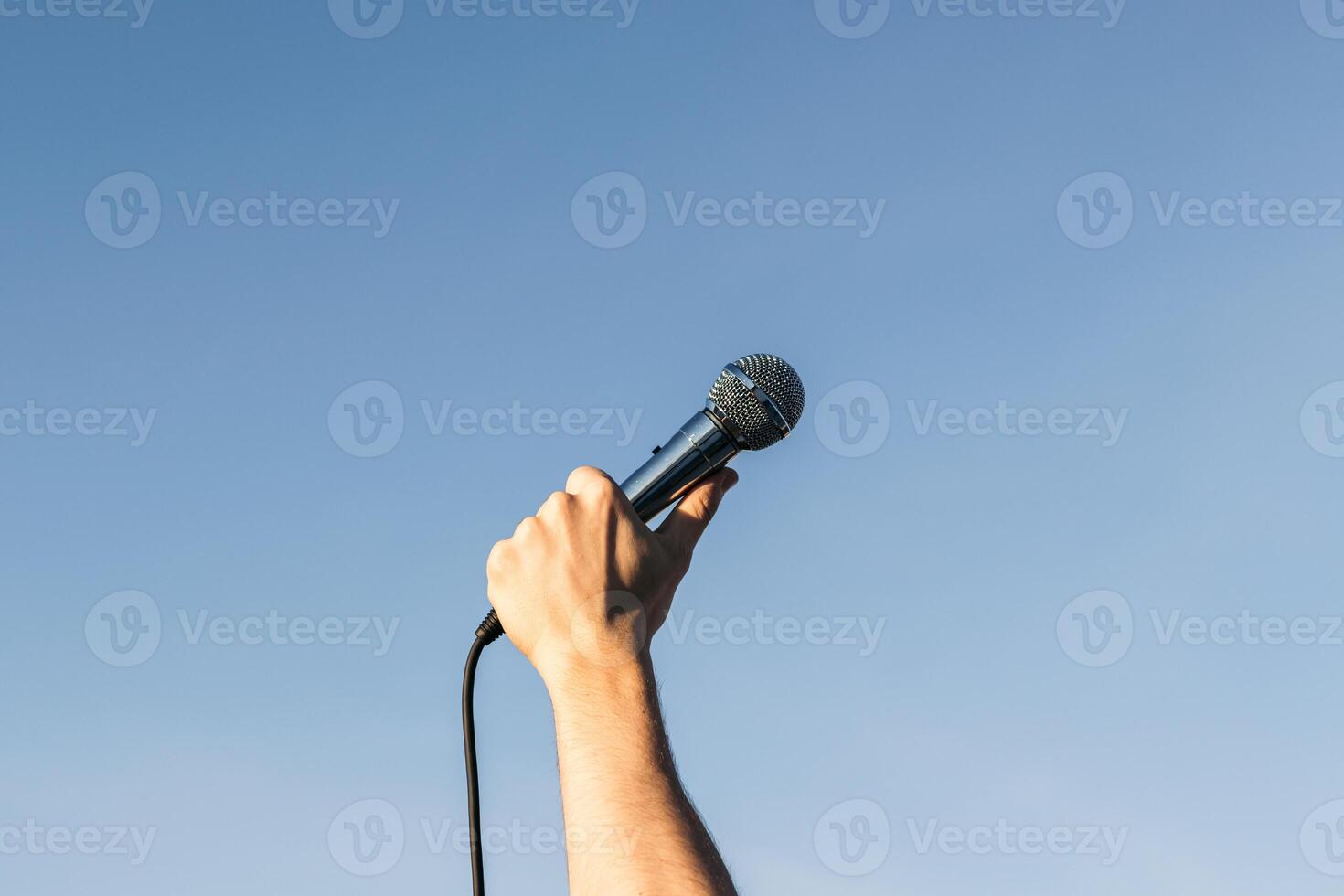 man hand holding a microphone photo