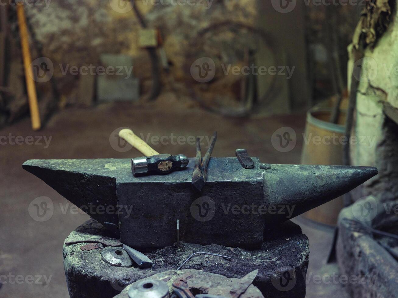 Anvil with hammer and tongs in forge photo