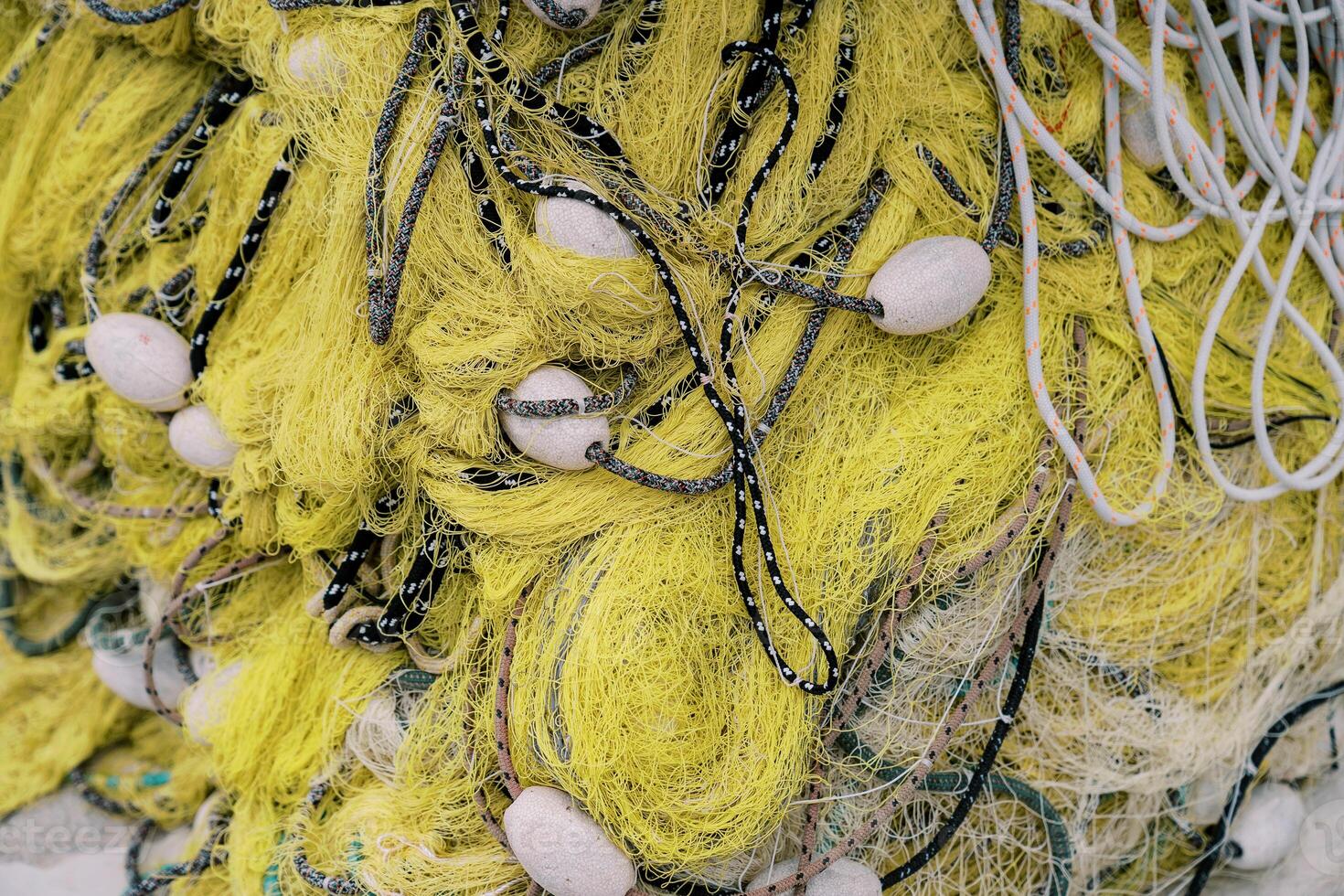 Folded yellow fishing net with white floats. Top view photo