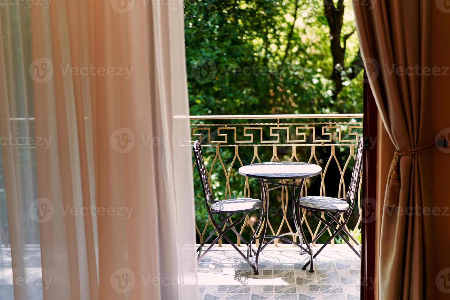View from the window to the terrace with a table and chairs on it photo