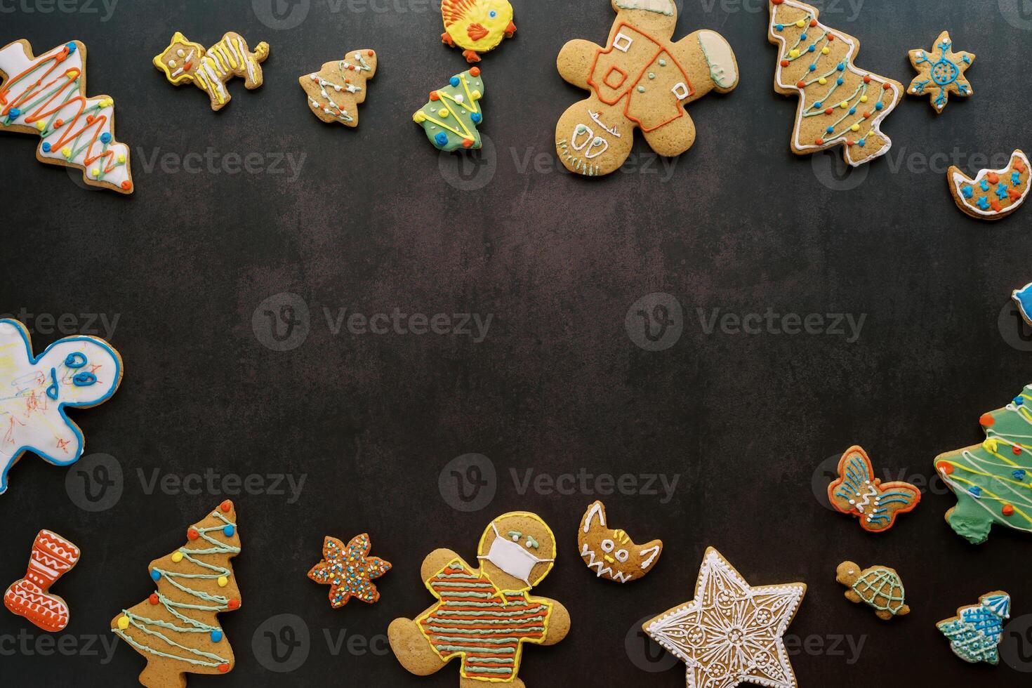 Glazed gingerbread ornament spread around the edges on a black background photo