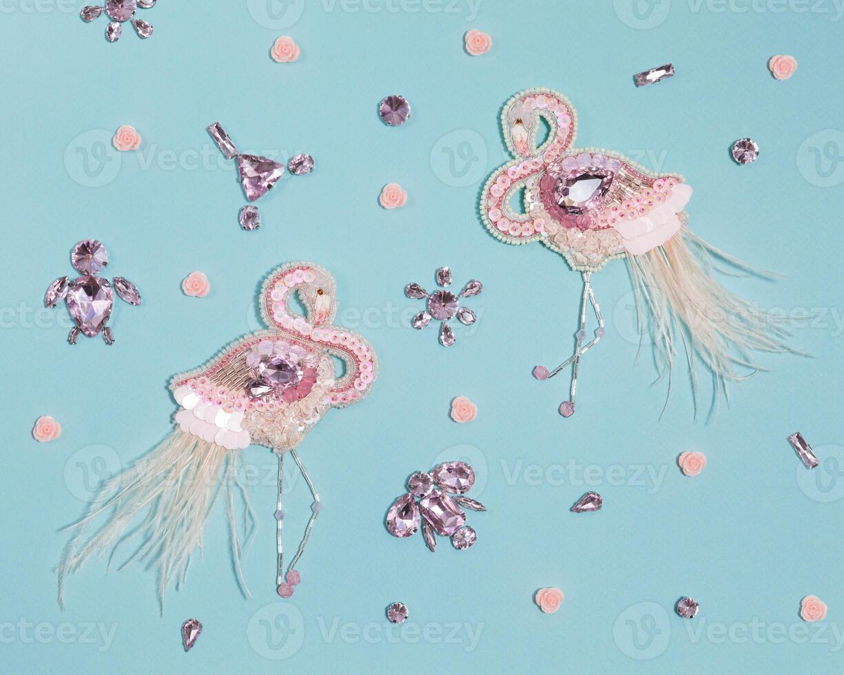 Gentle blue background with pink handmade flamingos and crystals photo