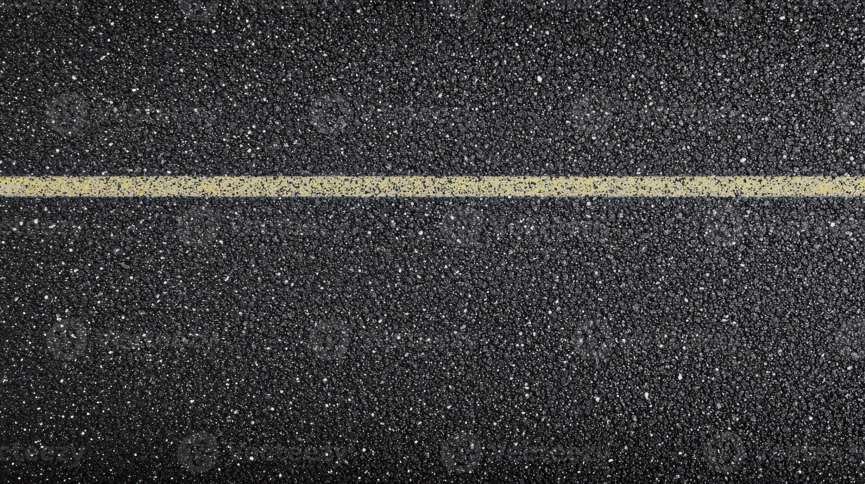 Yellow line on asphalt road surface displaying texture and pattern concept photo