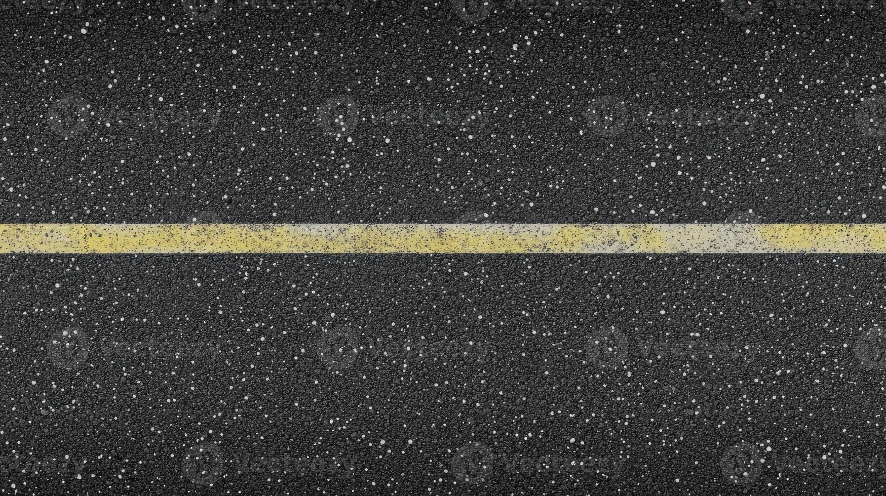 Close-up of road surface with single yellow line in asphalt texture photo