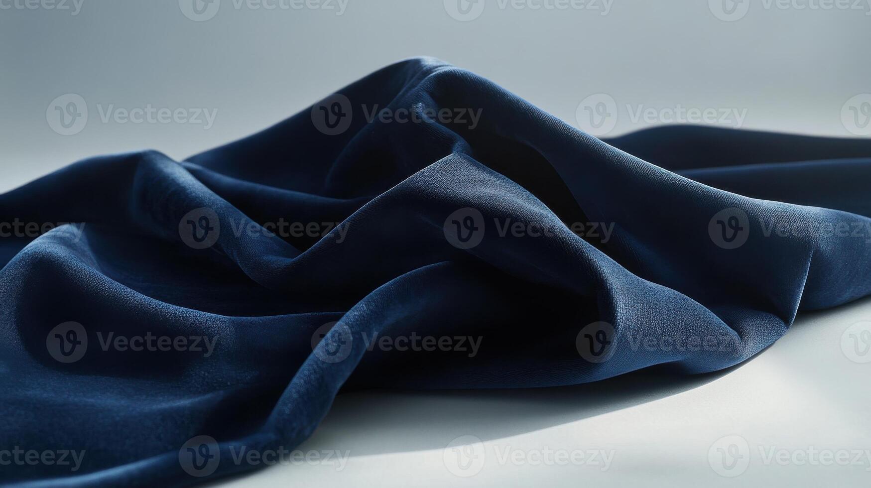 Elegant dark blue fabric with soft folds on light background concept photo