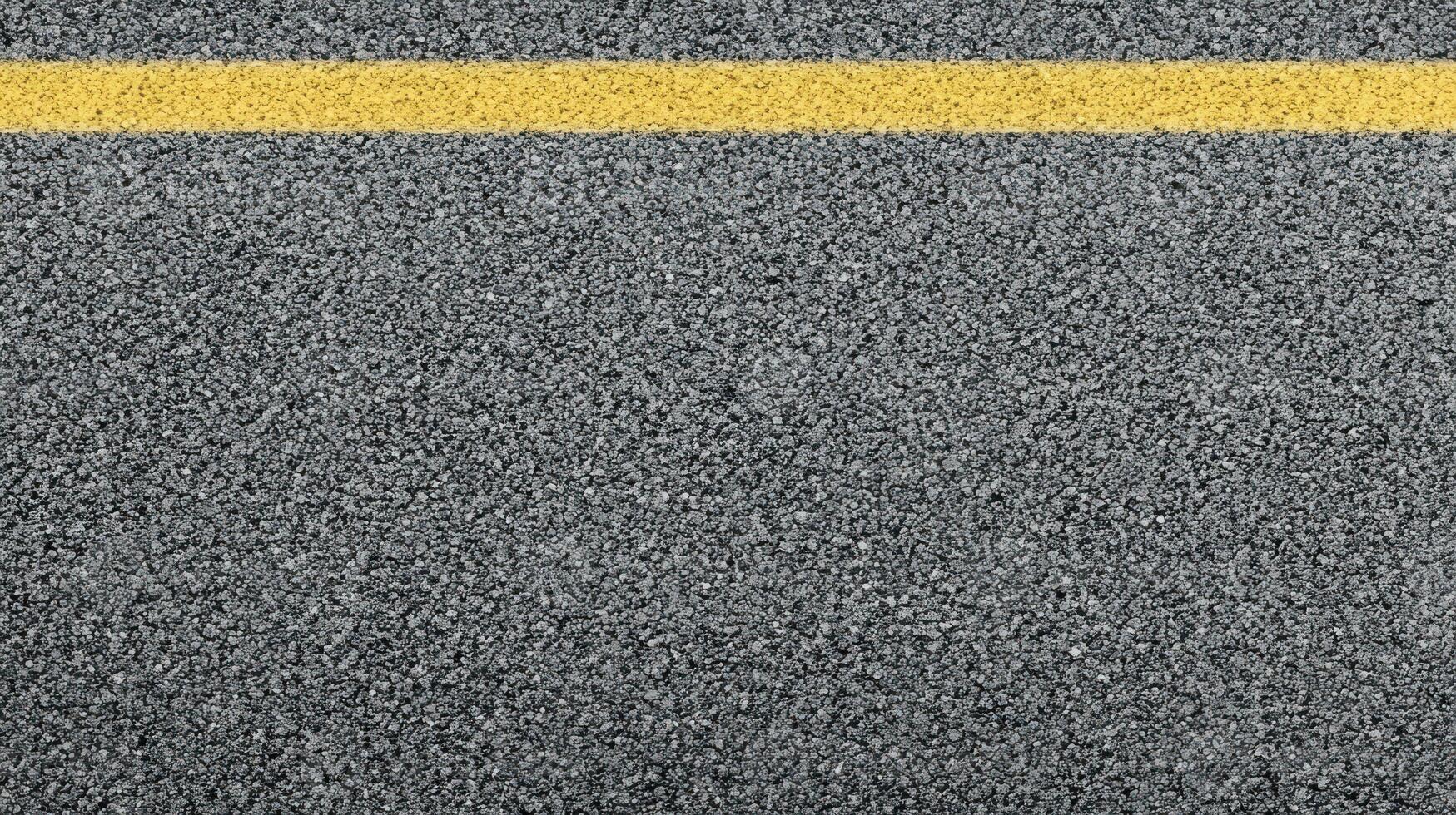 Close-up view of asphalt road surface with yellow line for transportation concept photo