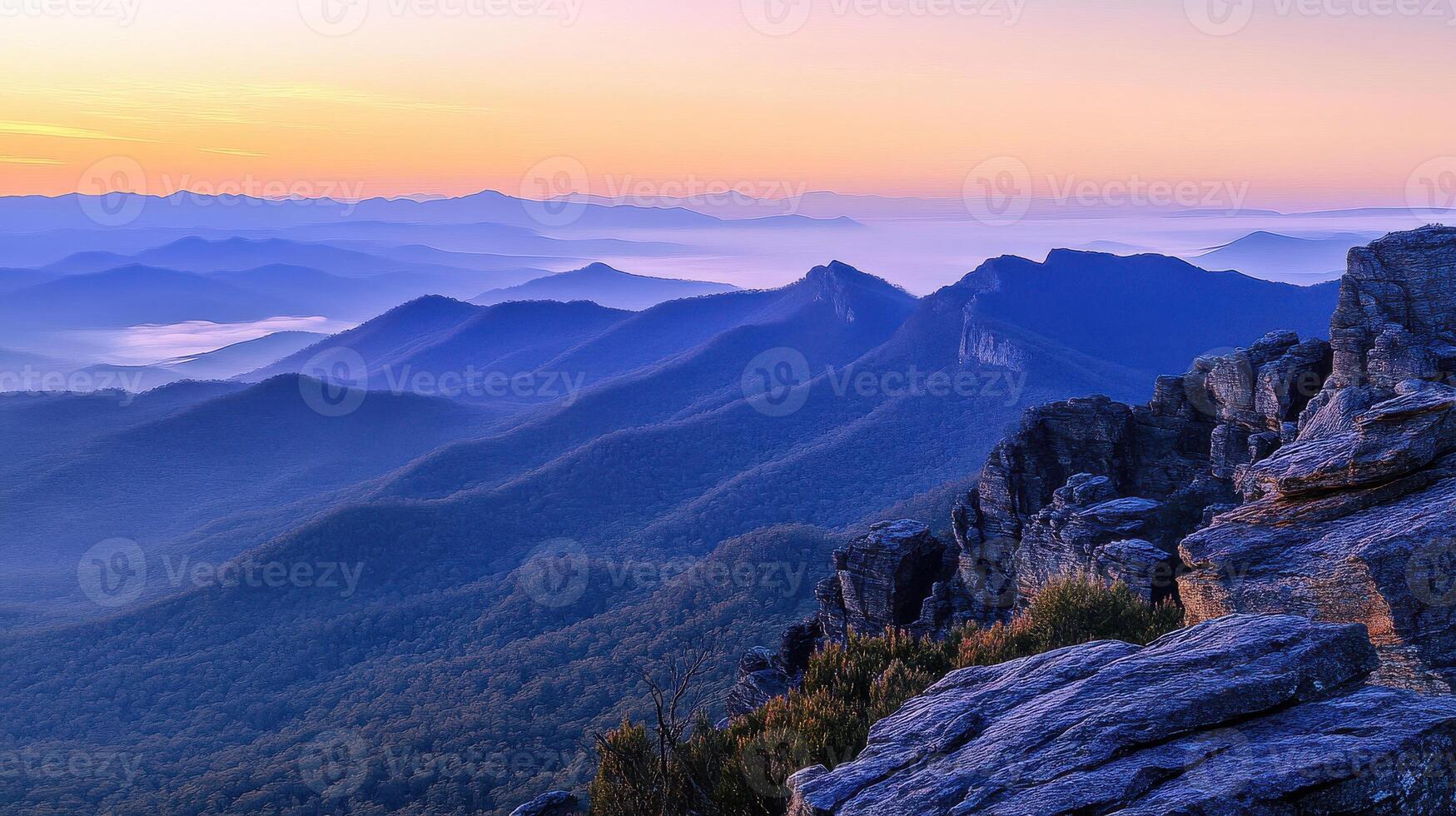 Stunning mountain range view at sunrise with fog rolling over hills and valleys photo