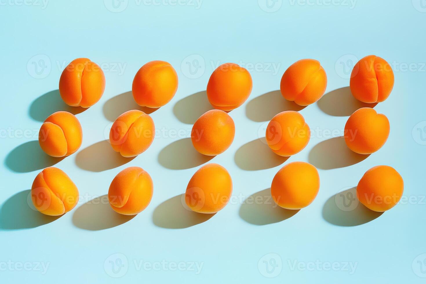 Fresh apricots with shadows on light blue background for summer fruit concept photo