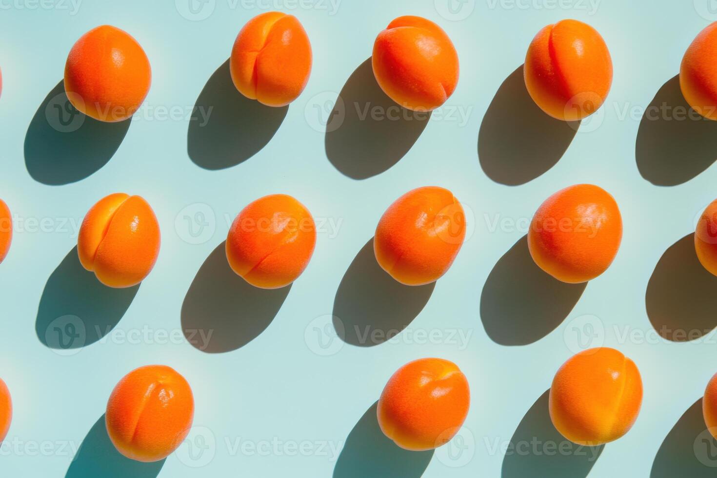 Fresh apricots in sunlight creating shadows against light blue background photo