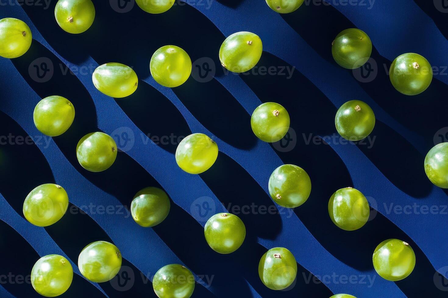 Green grapes pattern on dark blue background with shadows and light play photo