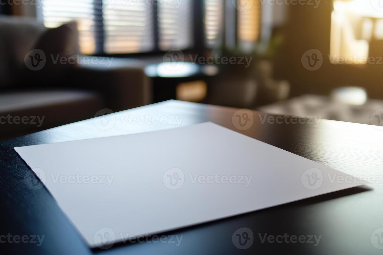 Empty white paper on a dark wooden table in a sunlit room setting photo