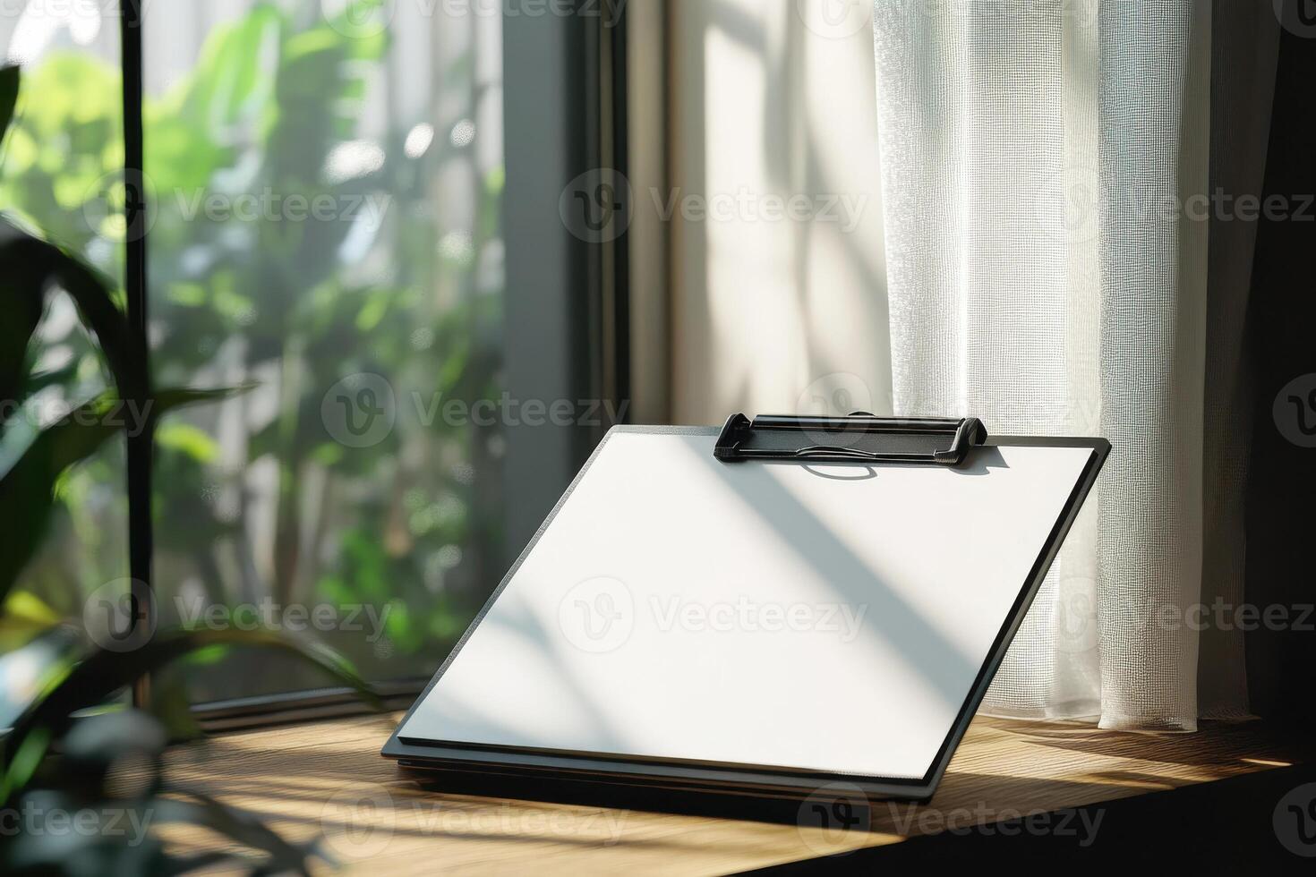 Empty clipboard on sunlit windowsill surrounded by lush green plants emphasizing workspace photo