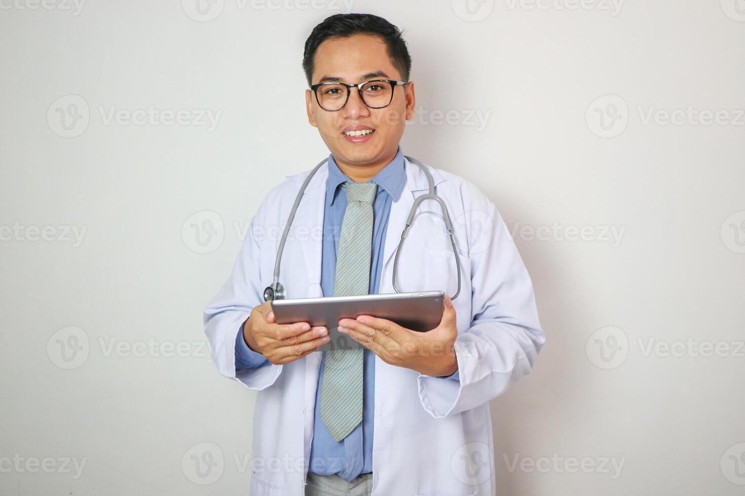Portrait of confident Asian Doctor in glasses with stethoscope using a digital tablet isolated on white background photo