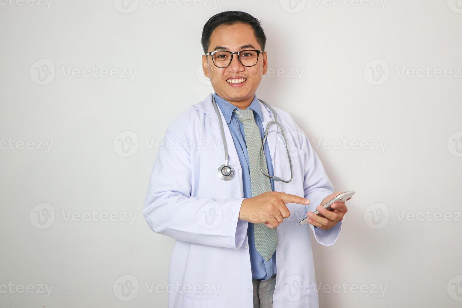 Portrait of male doctor using mobile phone and smiling isolated over white background. photo