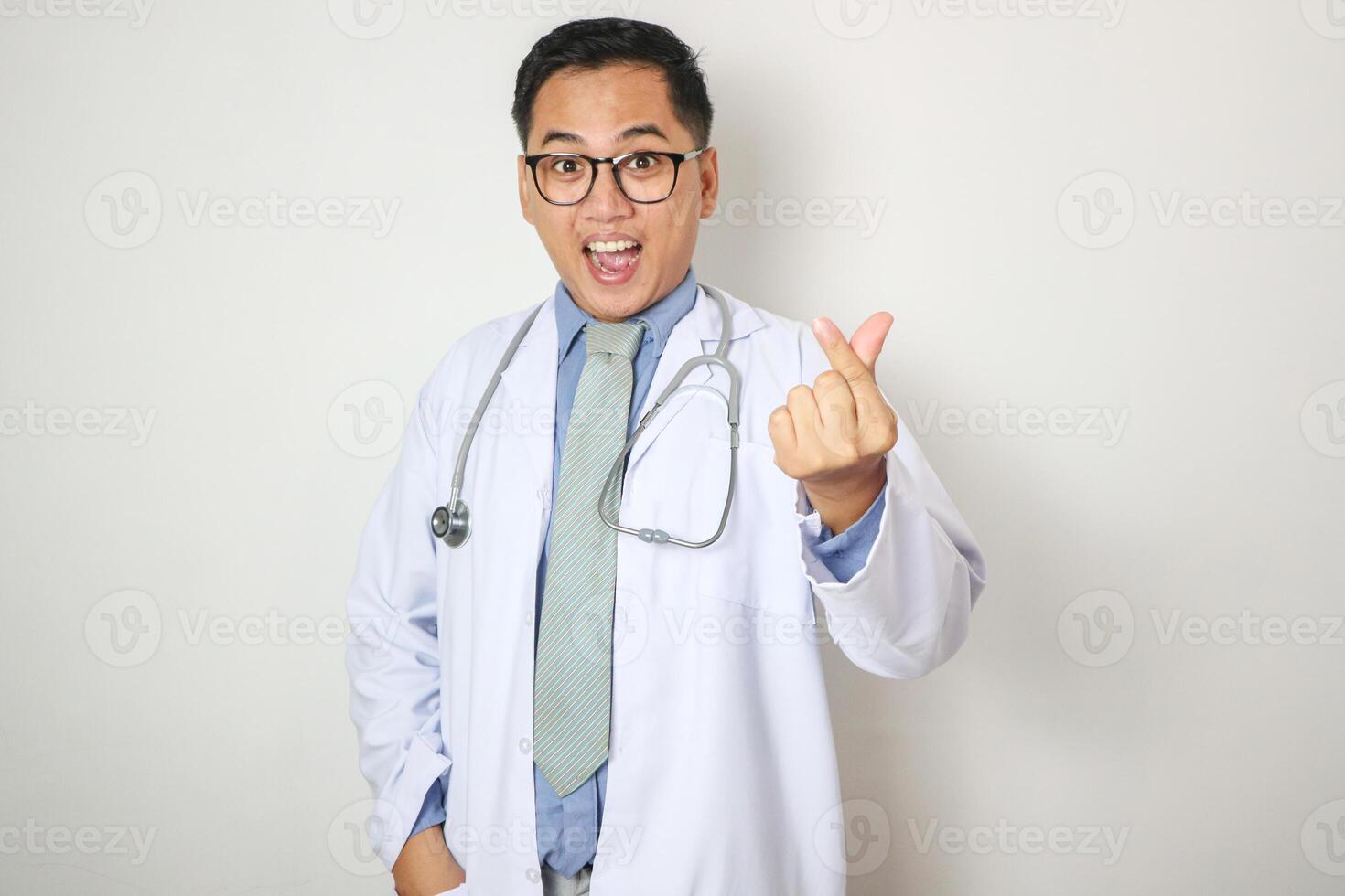 A portrait of a young Asian male doctor is showing heart finger or love gesture photo