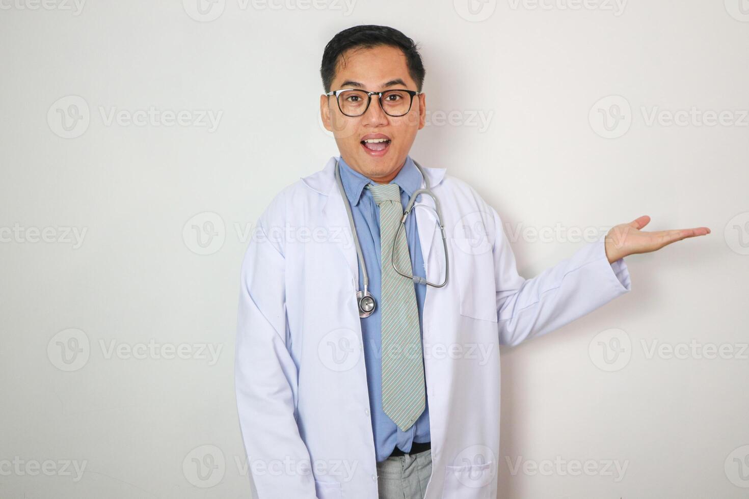 Asian man doctor medical professional holding something in empty hand, isolated on blue background with Clipping paths for design work empty free space photo
