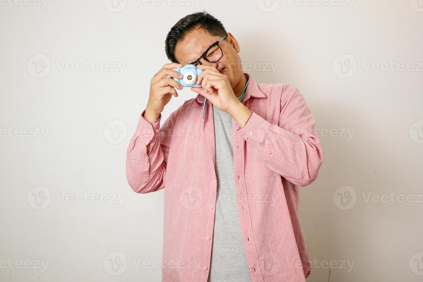 Traveling people concept.Portrait of Asian male backpacker photographer tourist isolated on white. Full body portrait. Taking Pictures with his mirrorrless photo