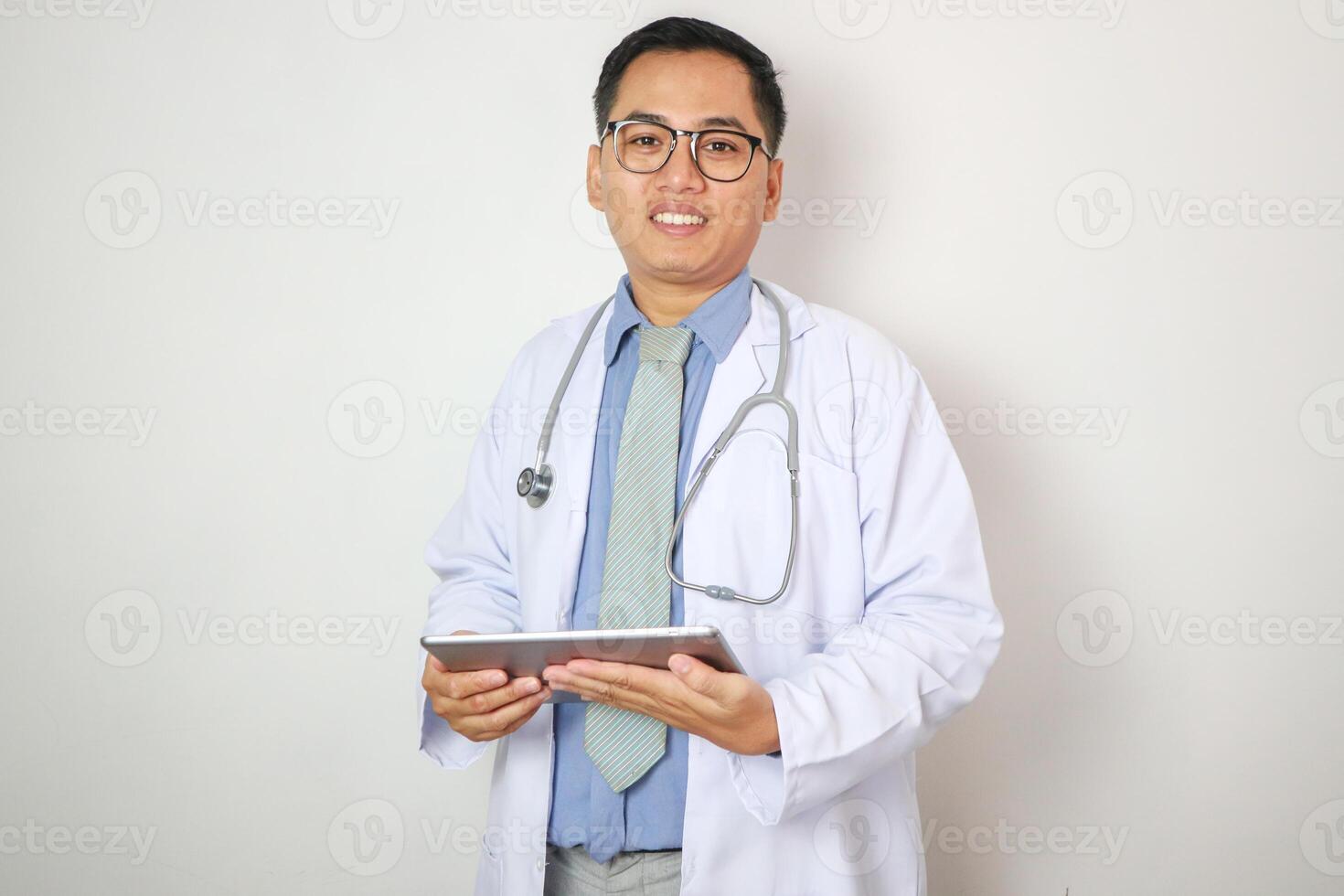 Telemedicine concept - asian male doctor is talking to patient by webcam with hello gesture and writing notes on digital tablet online photo
