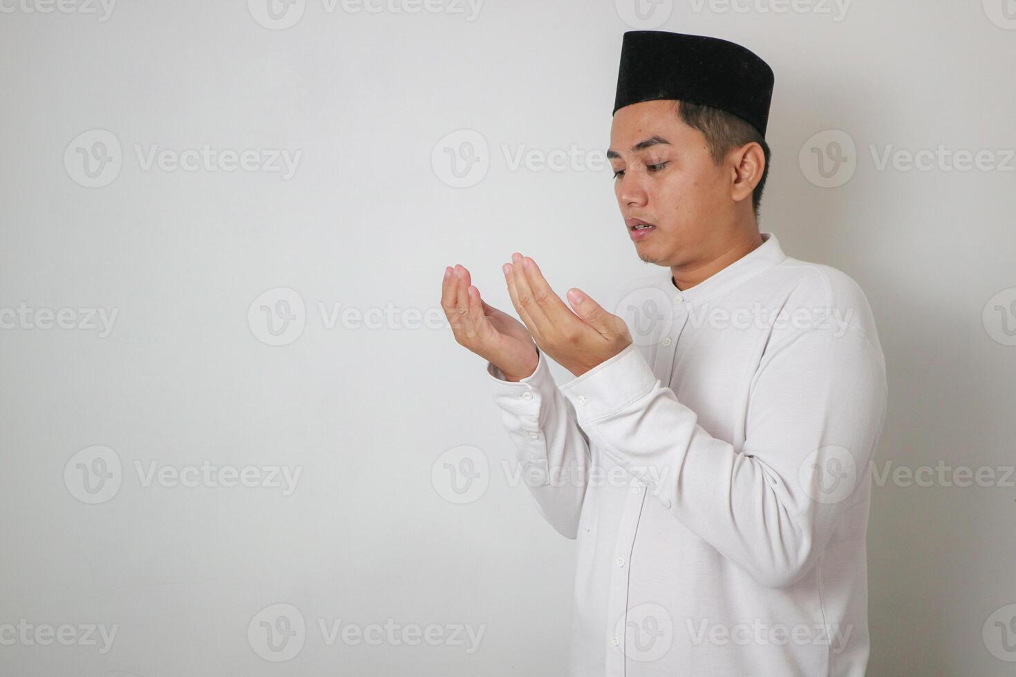 Asian muslim man showing his empty palm to the front, holding sometihing isolated on white background photo