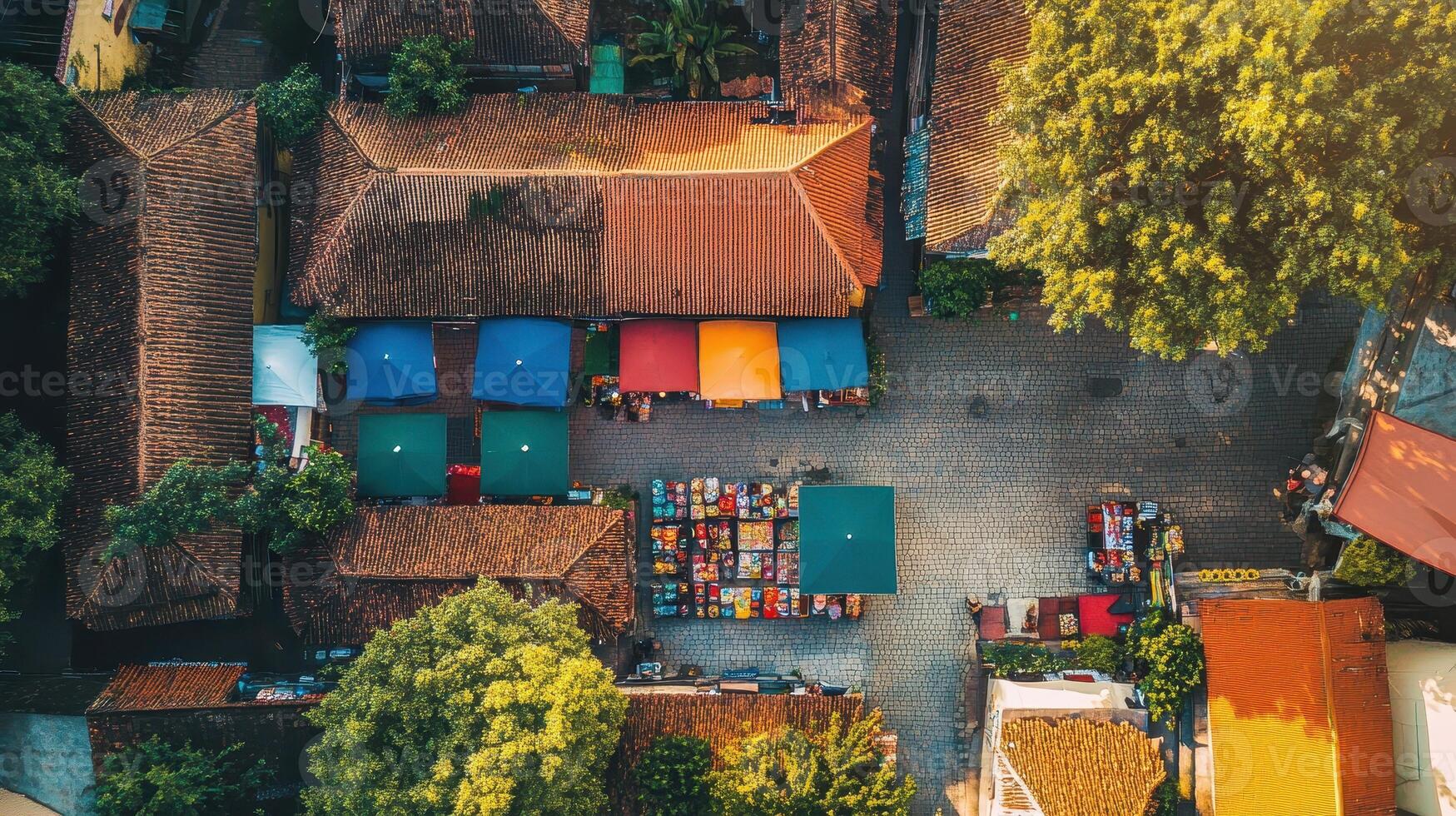 Aerial view of a vibrant market square with colorful tents and surrounding buildings. photo