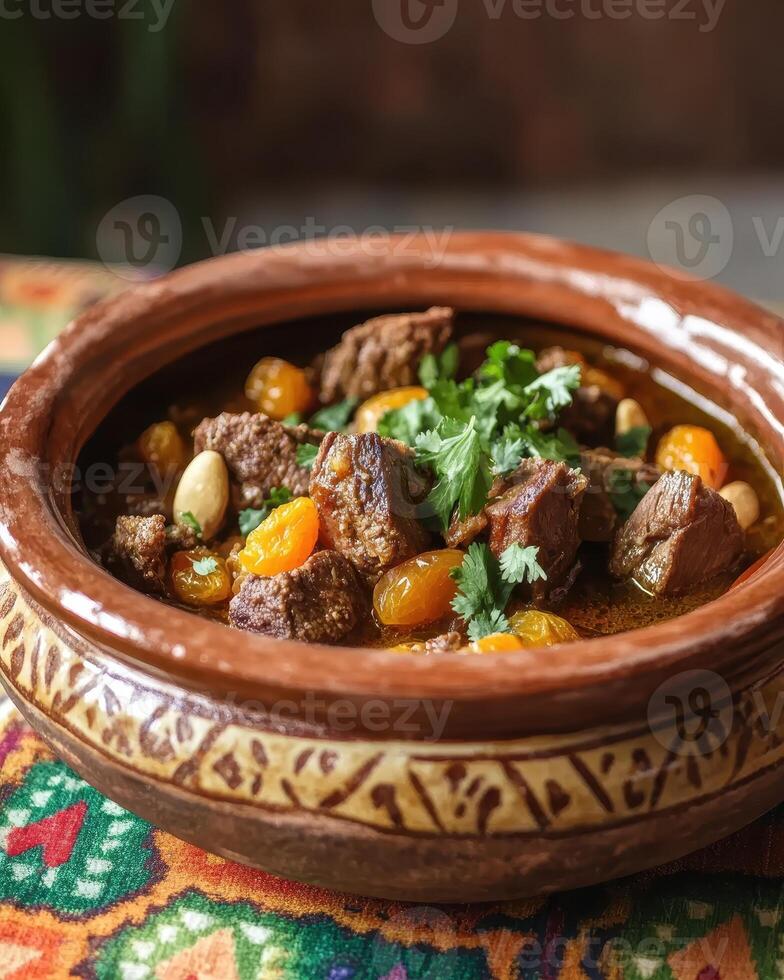 A rich meat stew served in a decorative clay pot, garnished with herbs and vegetables. photo