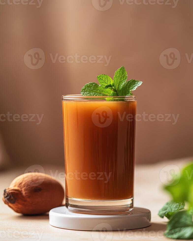 A refreshing drink garnished with mint, accompanied by a fruit on a wooden surface. photo
