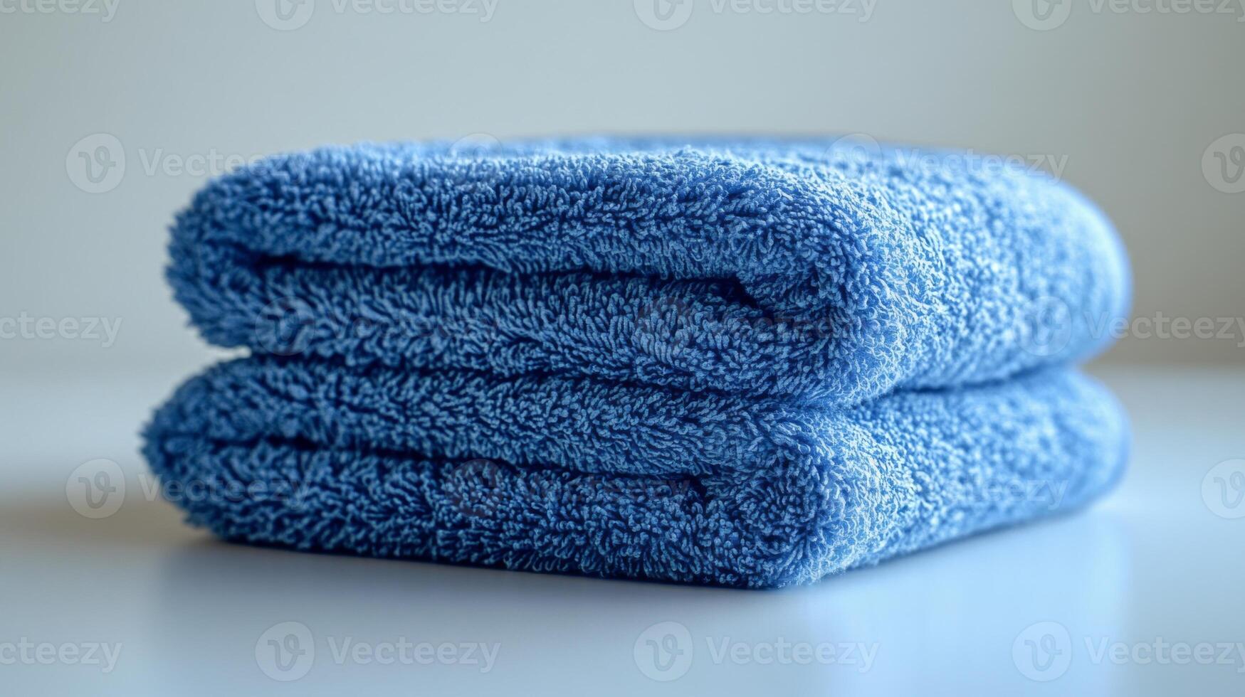 A stack of blue towels on a white surface photo