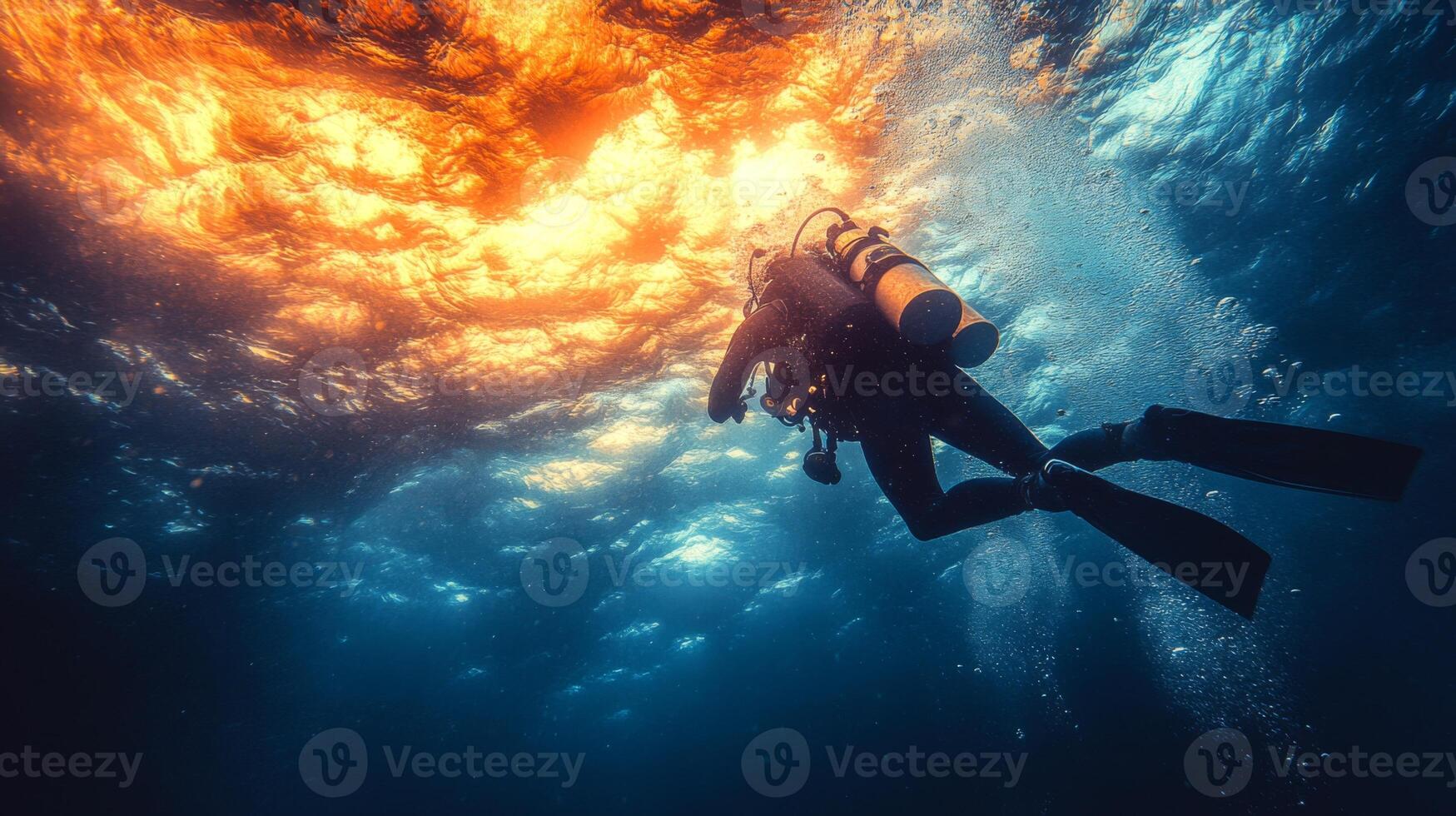 A scuba diver in the ocean with a sun shining through the water photo