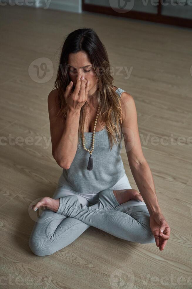Fit woman practicing yoga Pranayama breath control in studio photo