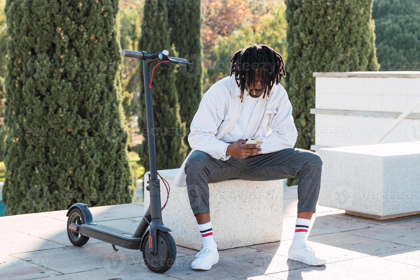 Black man with electric scooter in city photo