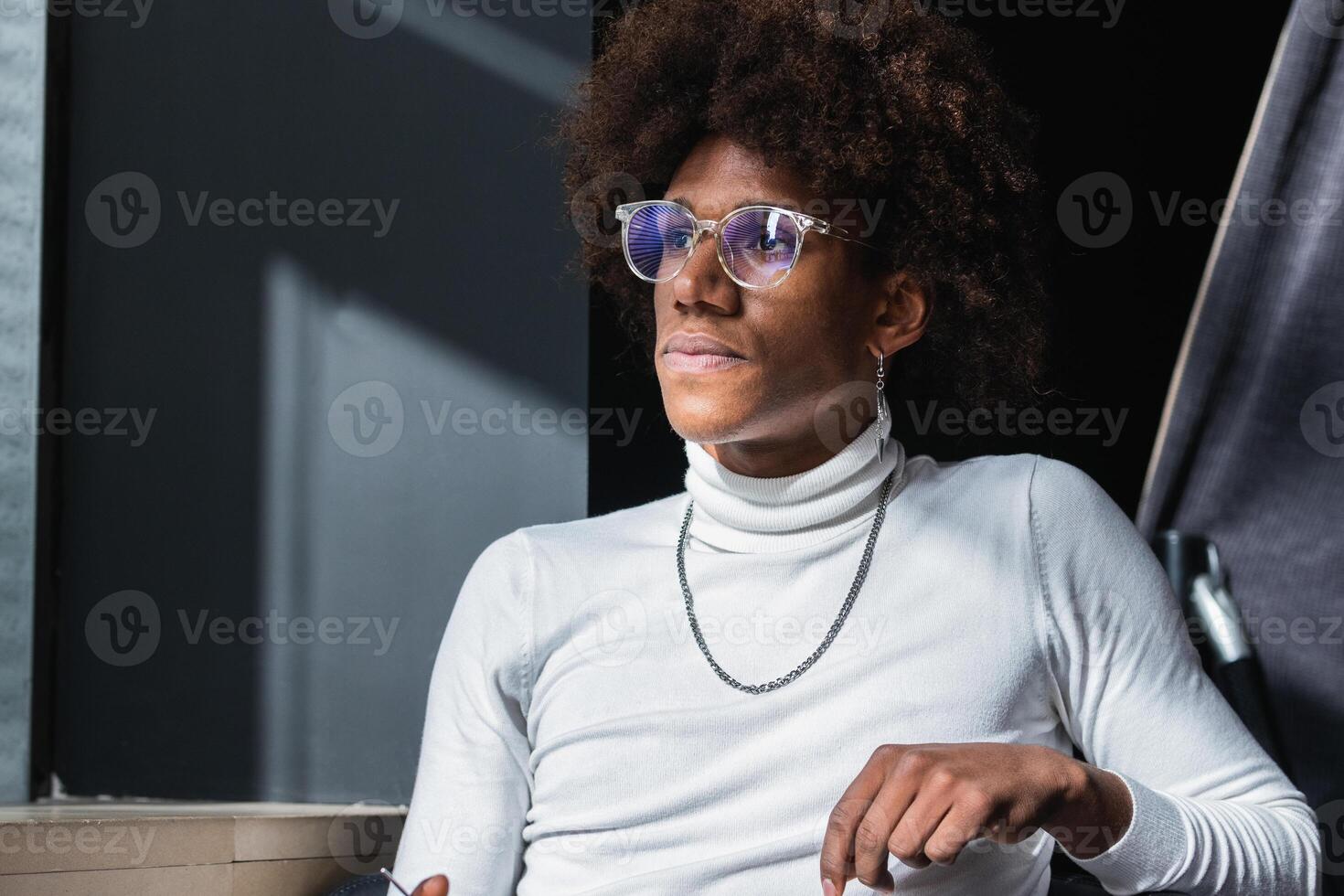 Stylish young African American guy chilling in cafe in sunlight photo
