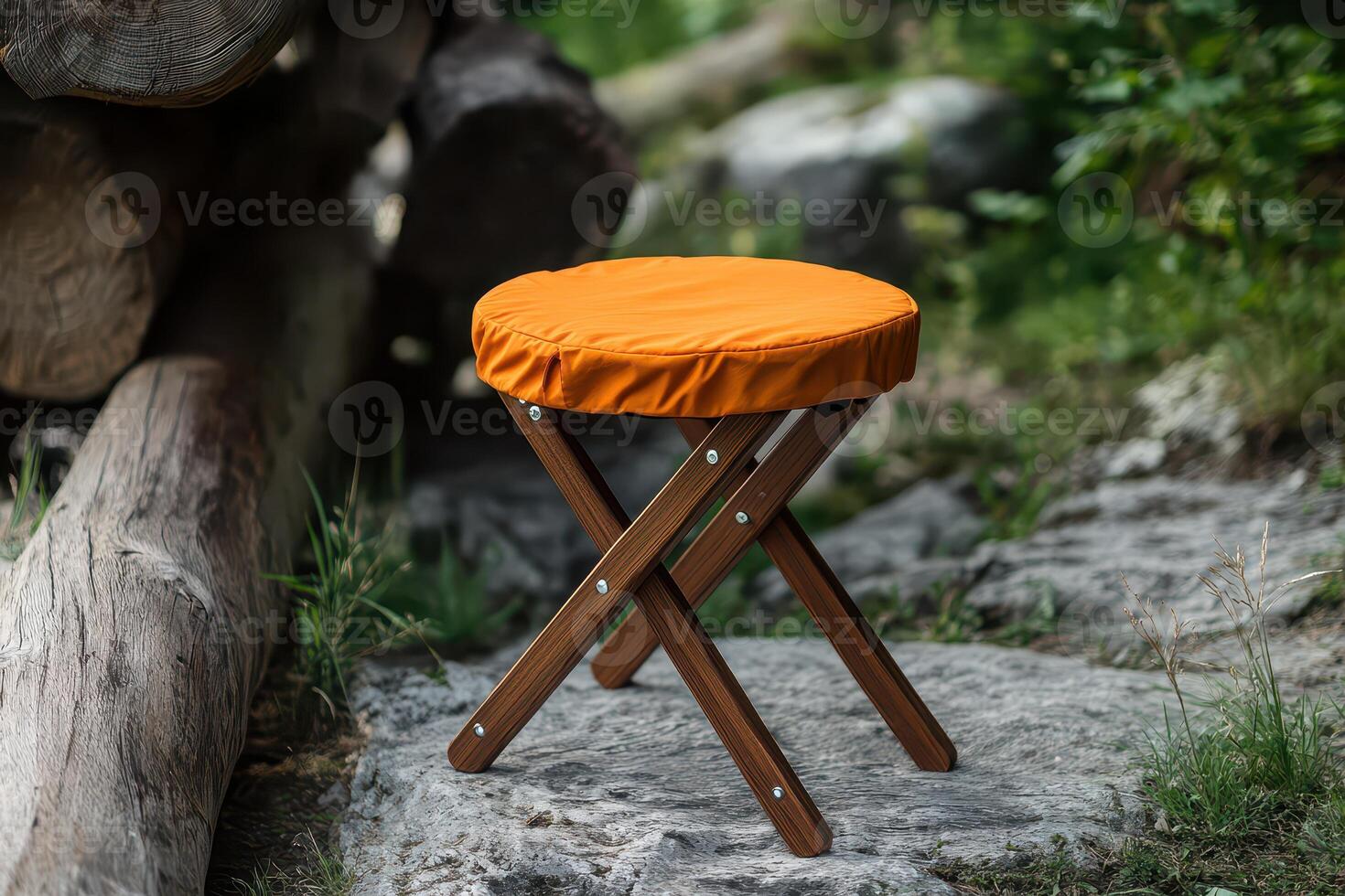 A wooden stool with an orange cover sitting on a rock photo