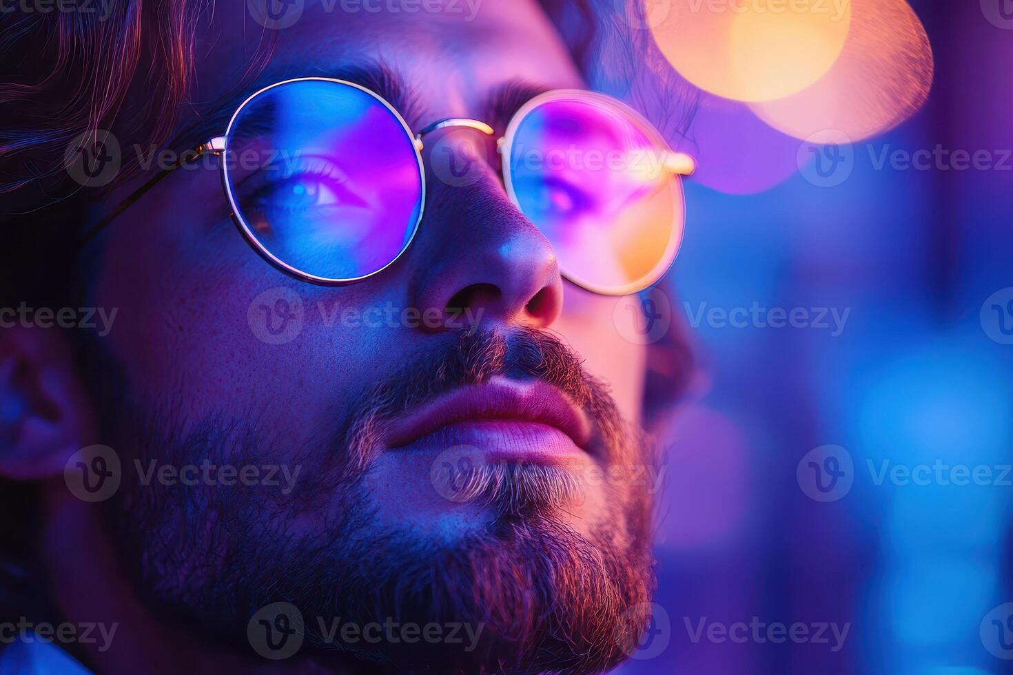 A man with glasses and beard in front of a colorful background photo