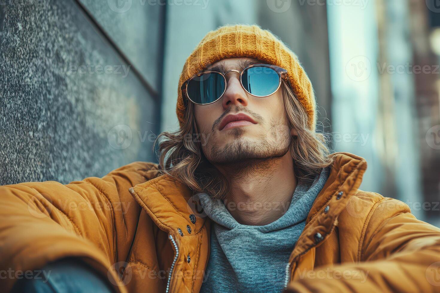 A man wearing sunglasses and a yellow hat photo