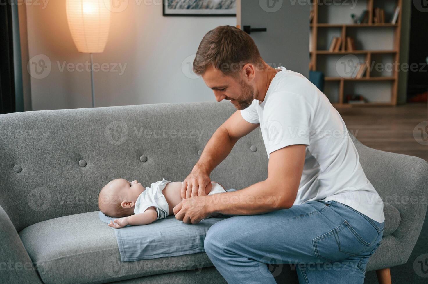 Changing diapers. Father with toddler ,is at home, taking care of his son photo