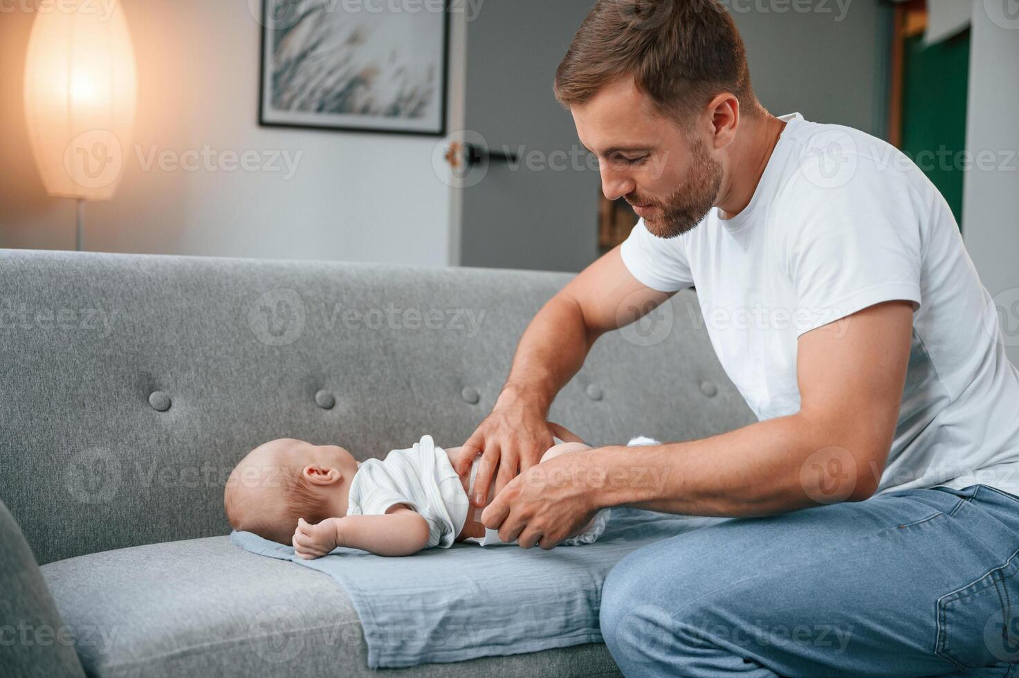 Changing diapers. Father with toddler is at home,, taking care of his son photo
