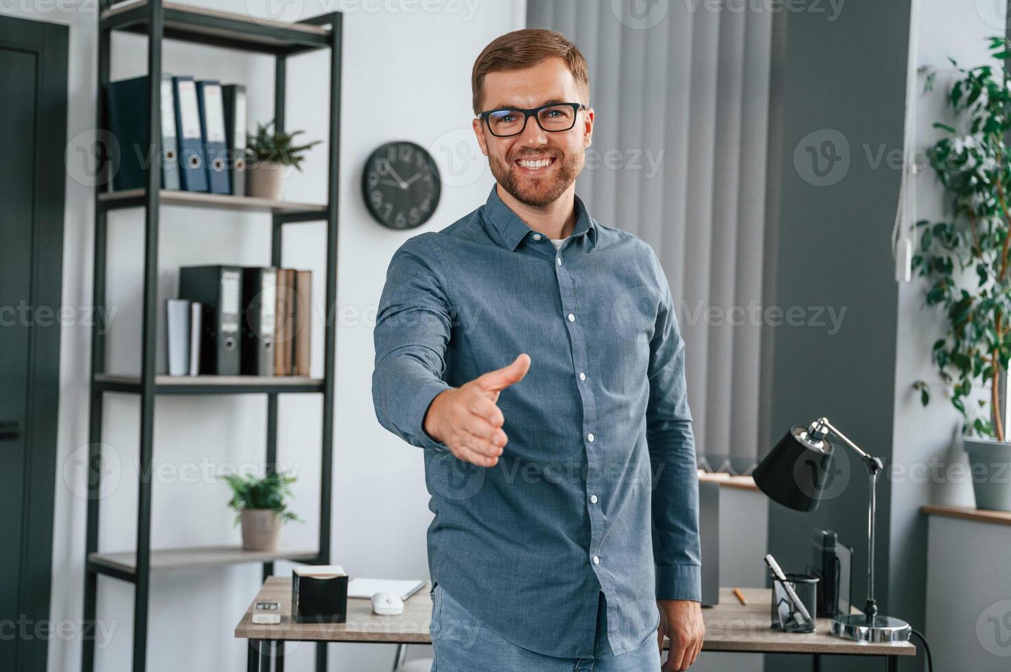 Giving hand. Man is working in the modern office. Conception of business and freelance photo