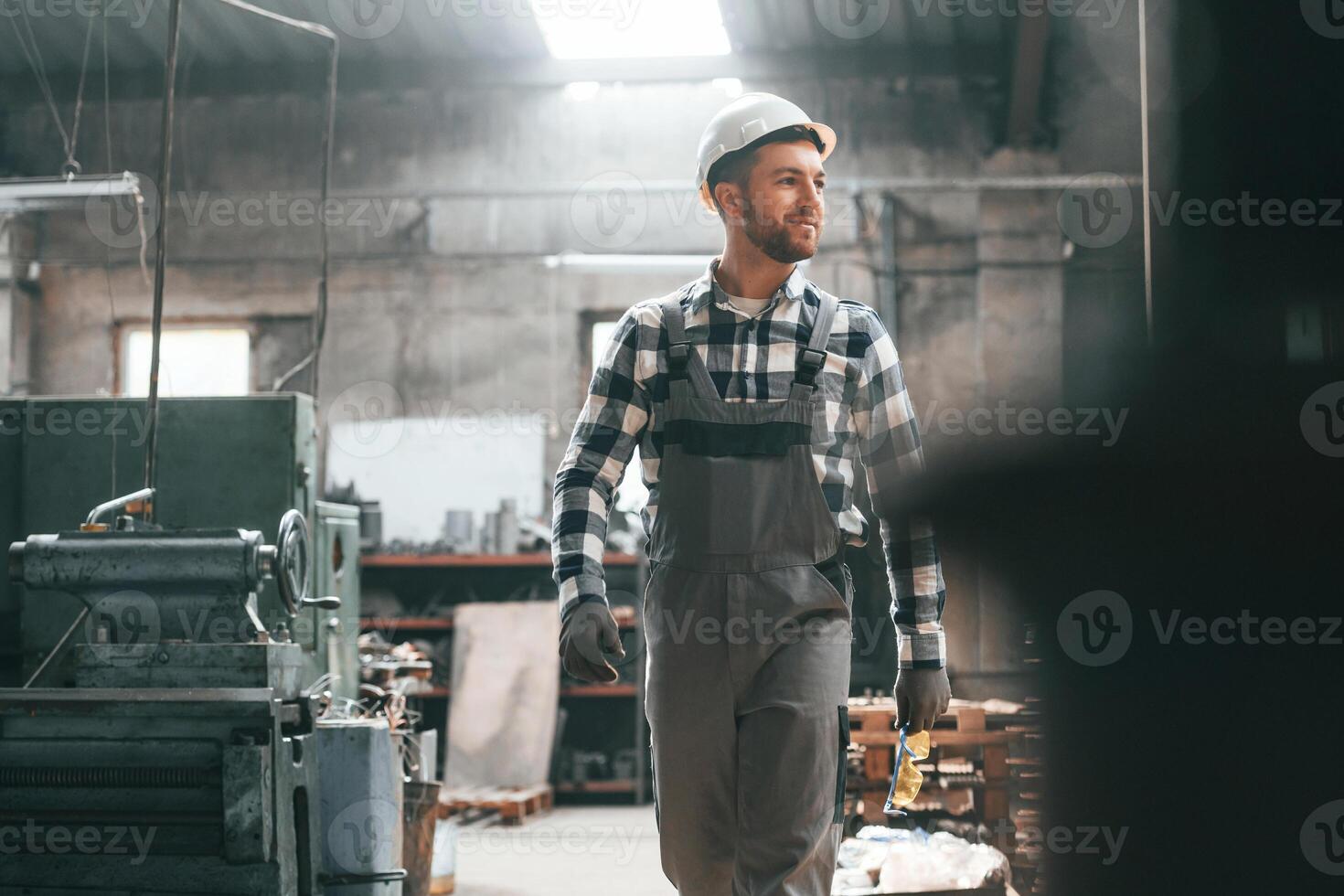 Front view.. Factory male worker in uniform is indoors photo