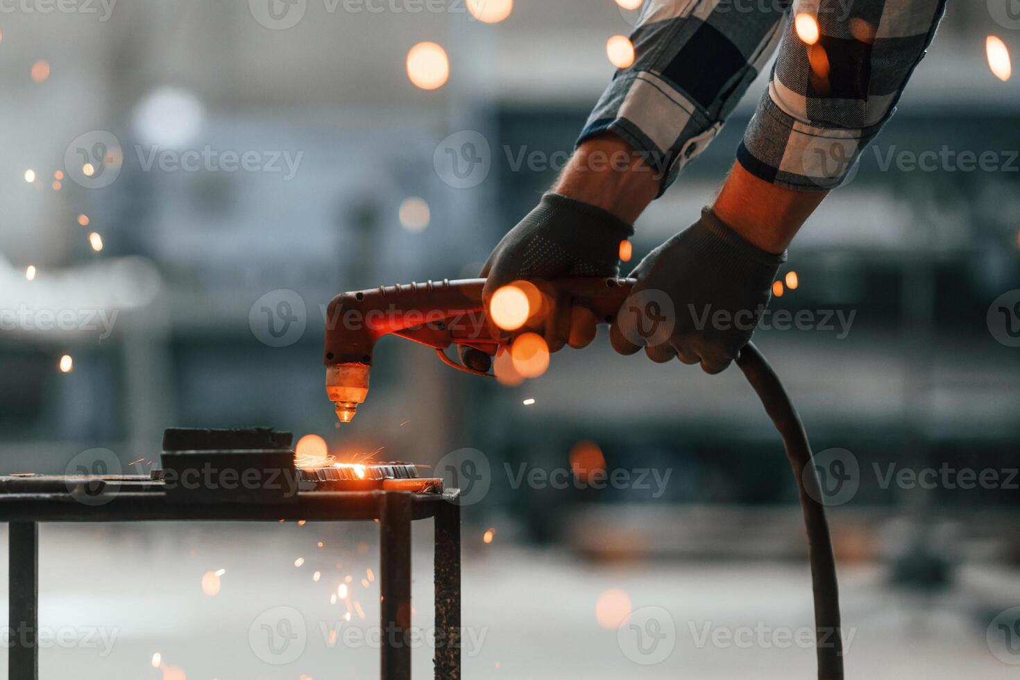 Process ,of welding.. Factory male worker in uniform is indoors photo