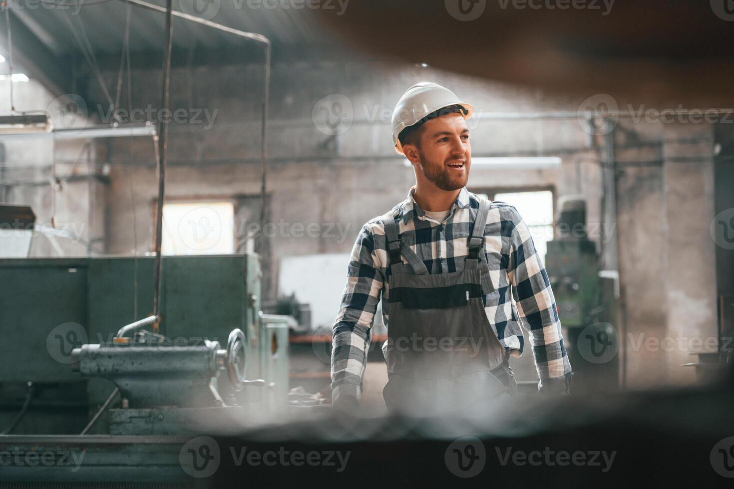 Front view. Factory male worker in uniform is indoors. photo