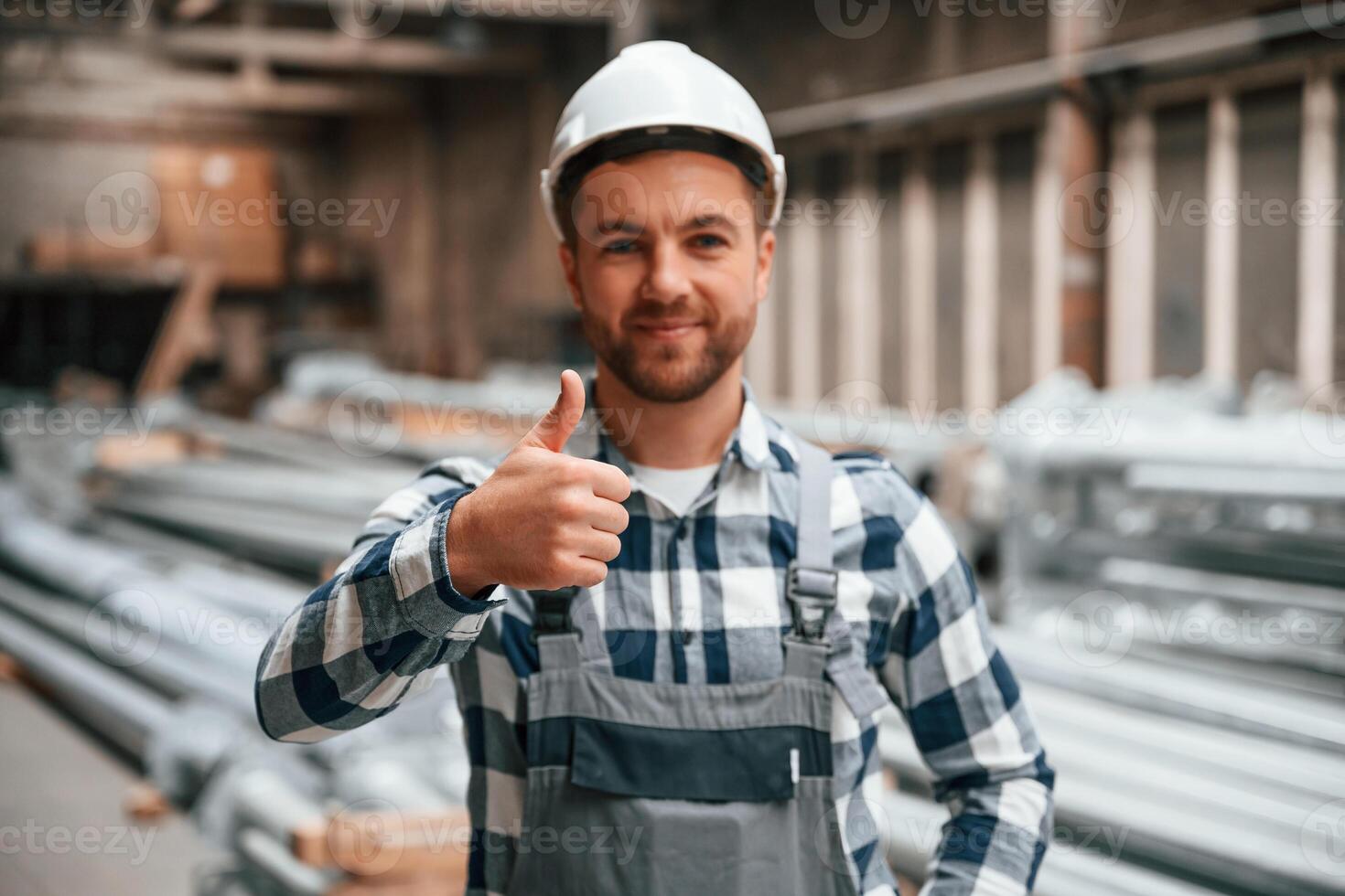 Friendly factory male worker in uniform is indoors photo