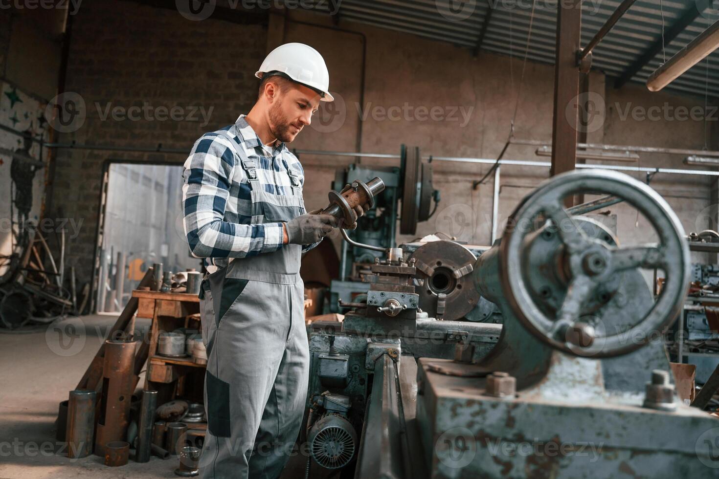 Metal processing. Factory male worker, in uniform is indoors photo