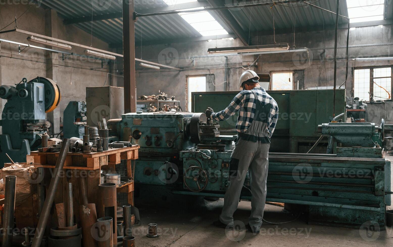 Back view. Factory male worker in uniform is indoors photo