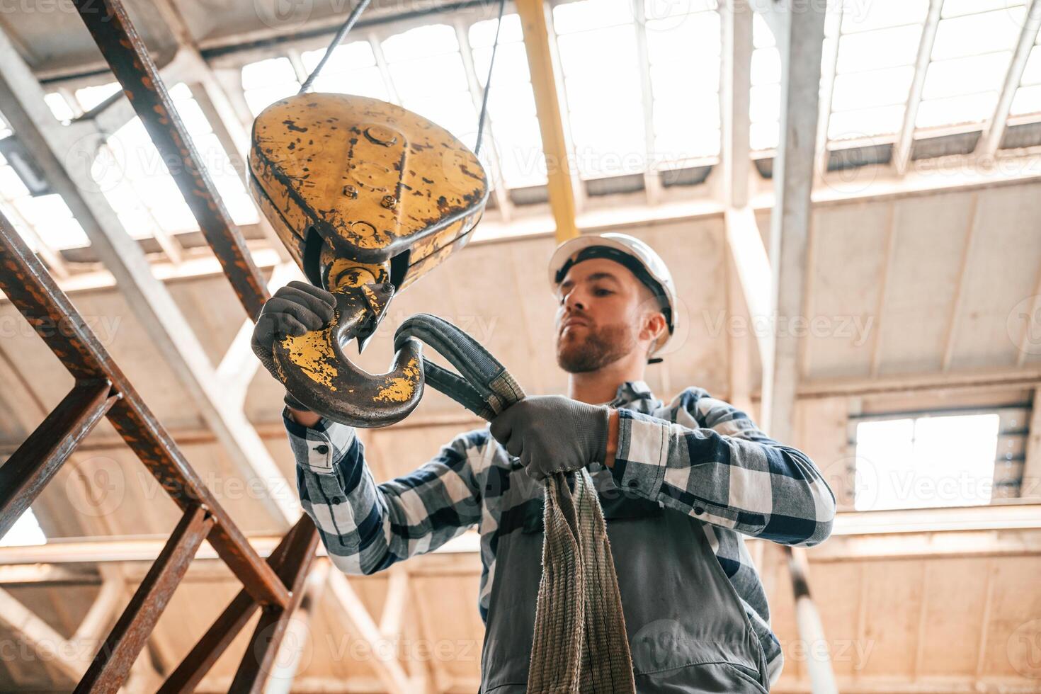 Working with crane.. Man in a factory in uniform is indoors photo