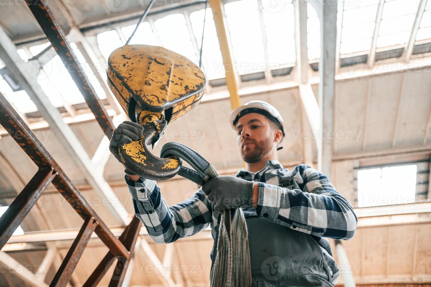 Working with crane. Man ,in a, factory in uniform is indoors photo