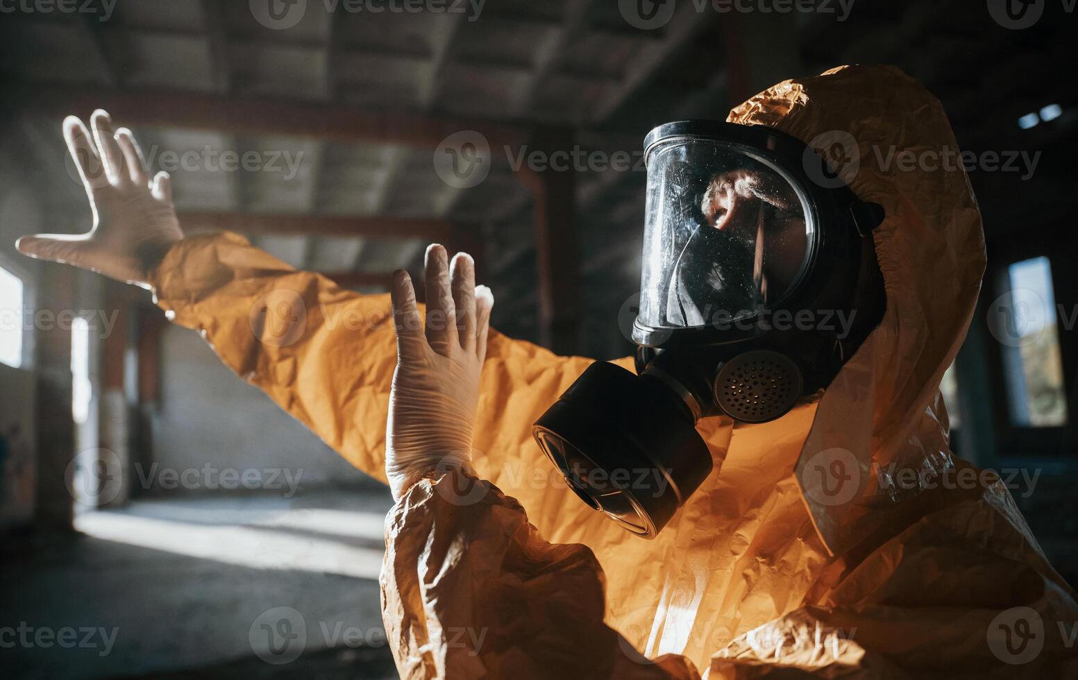 Light ,from nuclear explosion. Man dressed in chemical protection suit in the ruins of the post apocalyptic building photo