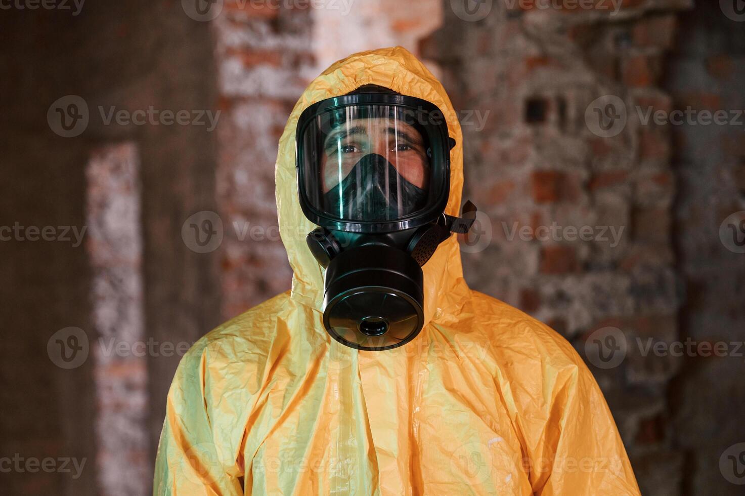 In, respirator, portrait. Man dressed in chemical protection suit in the ruins of the post apocalyptic building photo