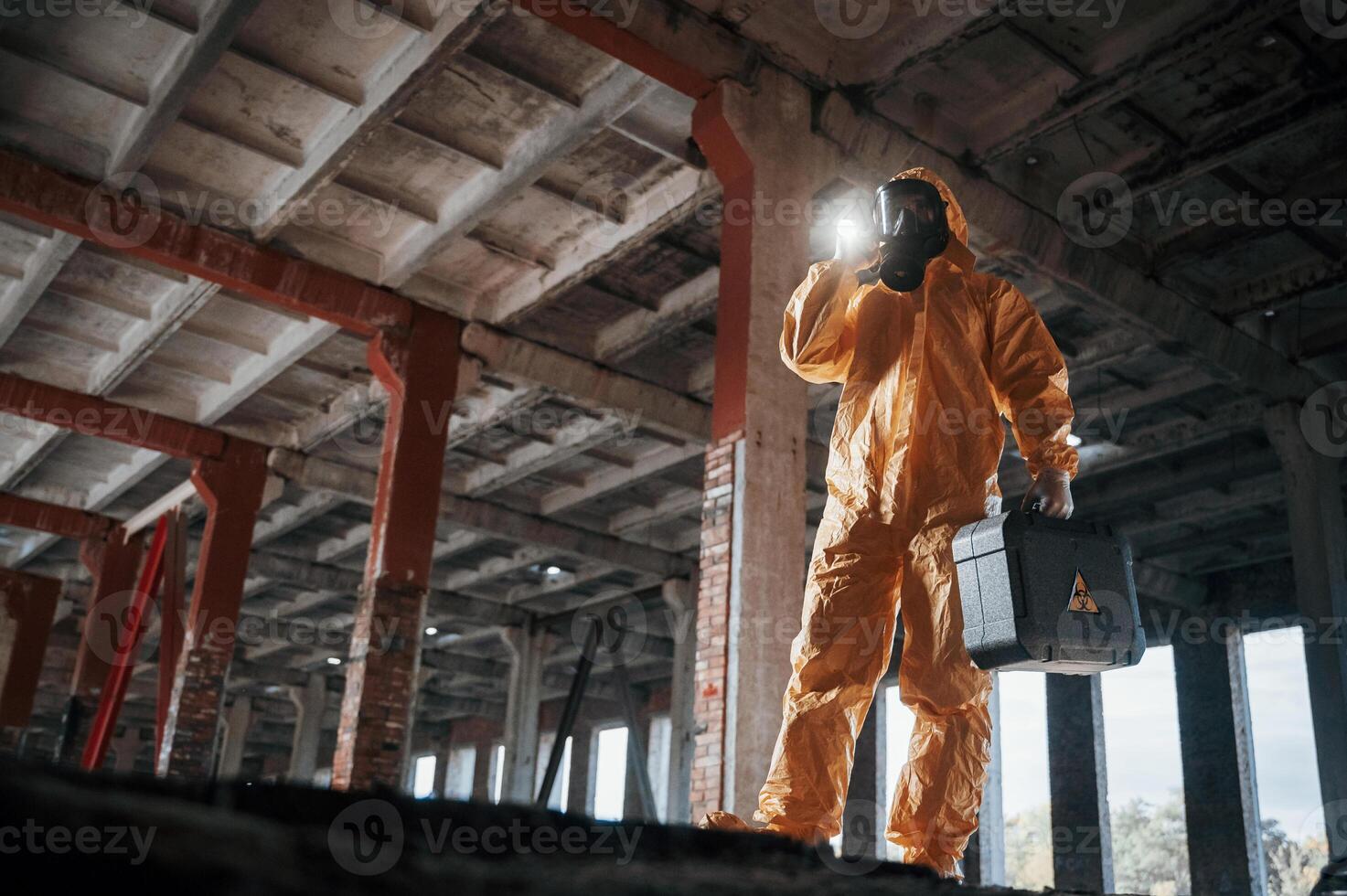 Bottom view. Man dressed in chemical protection suit in the ruins of the post apocalyptic building photo